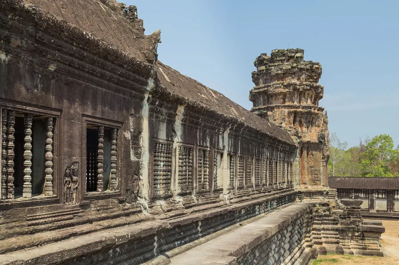Stone corridor with carved window balusters lines the outer gallery of Angkor Wat in Siem Reap.