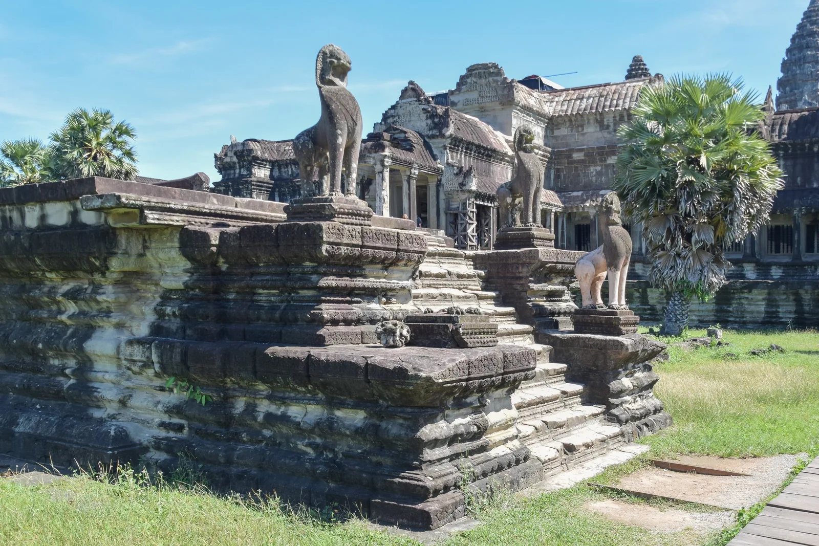 Stone lion statues guard weathered steps at Angkor Wat temple in Siem Reap, Cambodia.