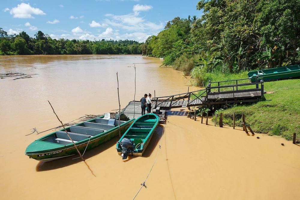 A small boat on the Kinabatangan under mist at first light A small boat on the Kinabatangan under mist at first light