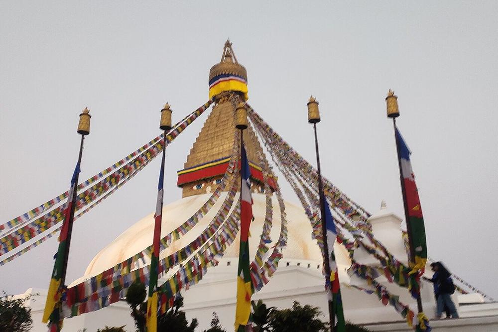 Walkers on the circuit around the white dome at Boudhanath at dusk Walkers on the circuit around the white dome at Boudhanath at dusk