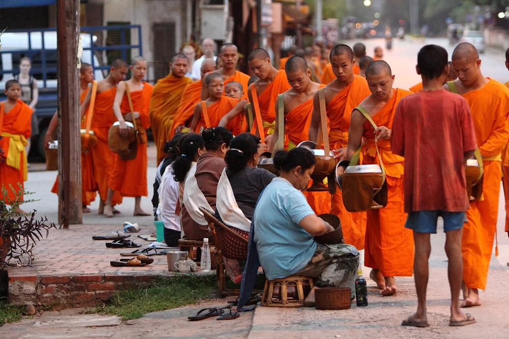 Monks walking the alms round at dawn on a Luang Prabang street Monks walking the alms round at dawn on a Luang Prabang street